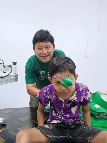 A child receiving follow-up eye care with support from Dr. Nay Hser
